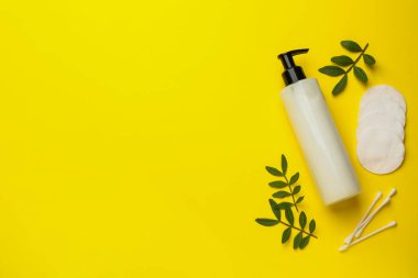 Pamuk pedler, pamuklar ve makyaj malzemesi sarı arka planda, düz yerde. Metin için boşluk