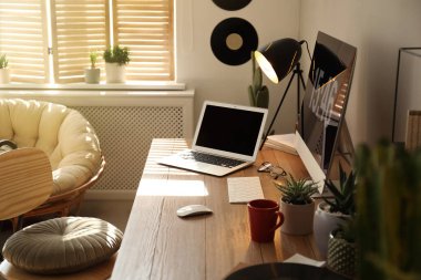 Modern bilgisayar ve dizüstü bilgisayar odasındaki ahşap masada. İç tasarım