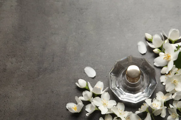 Fles Luxe Parfum Verse Jasmijnbloemen Grijze Tafel Plat Gelegd Ruimte — Stockfoto