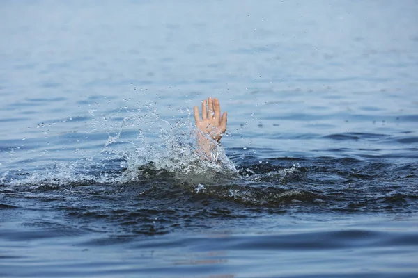 Drowning man reaching for help in sea, closeup