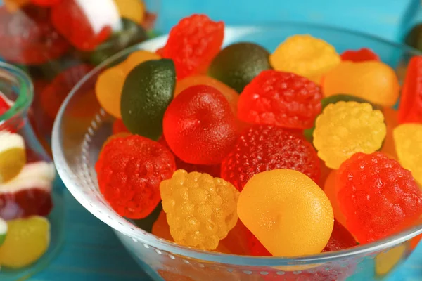 Delicious gummy fruit shaped candies in glass bowl, closeup