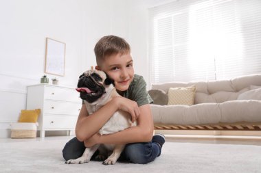 Çocuk oturma odasında sevimli köpeğine sarılıyor. Metin için boşluk