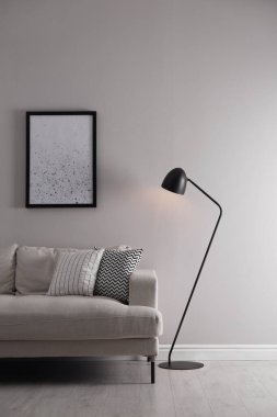 Rahat kanepe ve zemin lambası olan şık bir oturma odası.