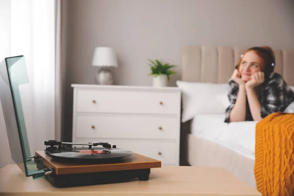 寝室で音楽を聴いている若い女性 ターンテーブルに焦点を当てる — ストック写真