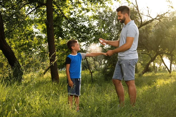 Mann Sprüht Seinem Sohn Park Insektenschutzmittel Auf Den Arm Vorbeugung — Stockfoto