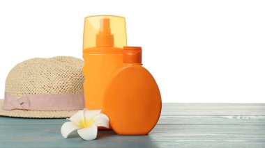 Mavi ahşap masada güneş koruma ürünleri ve plaj aksesuarları. Metin için boşluk