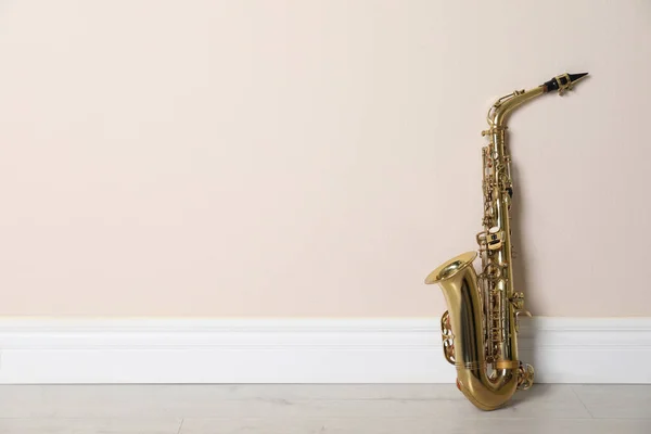 Piękny Saksofon Podłodze Przy Beżowej Ścianie Wewnątrz Miejsce Tekst — Zdjęcie stockowe