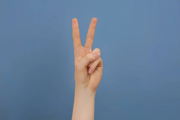 Žena Ukazuje Dva Prsty Světle Modrém Pozadí Detailní Záběr — Stock fotografie
