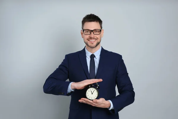 Glücklicher Geschäftsmann Mit Wecker Auf Grauem Hintergrund Zeitmanagement — Stockfoto