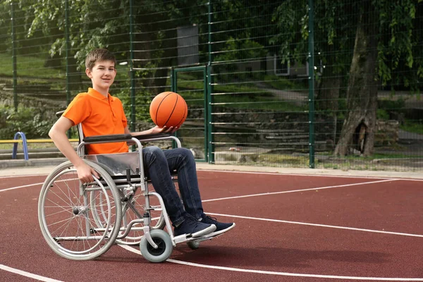 Niepełnosprawny Nastolatek Wózku Inwalidzkim Piłką Koszykówki Boisku — Zdjęcie stockowe