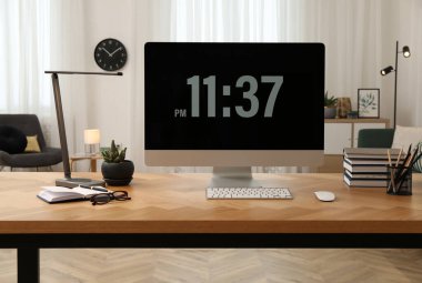 Odanın ahşap masasında modern bilgisayarla rahat bir iş yeri. İç tasarım