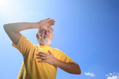 Senior man suffering from heat stroke outdoors clipart