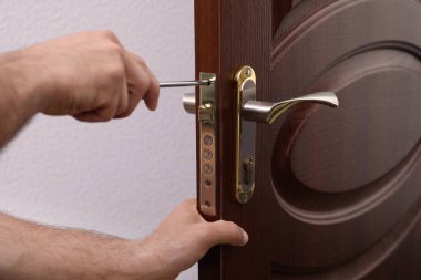 Tornavidalı tamirci kapı kilidini tamir ediyor, yakın plan.