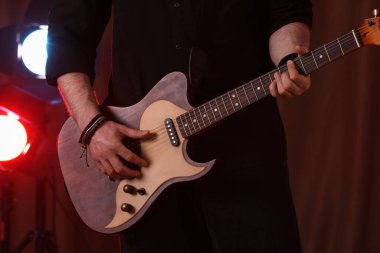 Sahnede elektro gitar çalan adam, yakın plan. Rock müzik