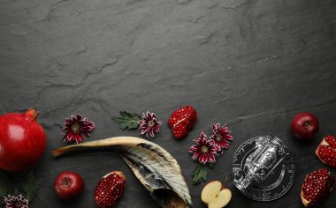 Siyah arka planda Rosh Hashanah 'ın tatil özelliklerinin olduğu düz kompozisyon. Metin için boşluk