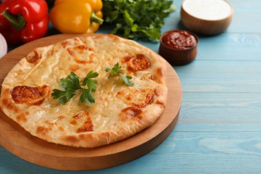 Açık mavi ahşap masada peynirli nefis khachapuri, metin için yer var.