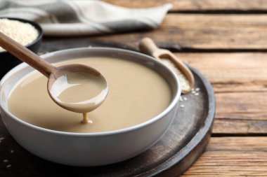 Tahta masanın üzerinde lezzetli susamlı kaşık, yakın plan.