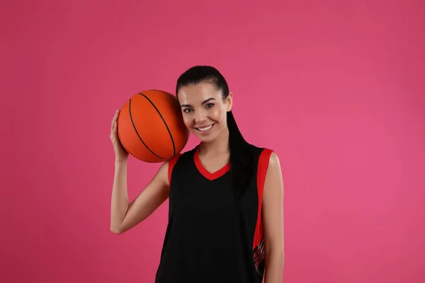 バスケットボール選手 ピンクの背景にボール — ストック写真