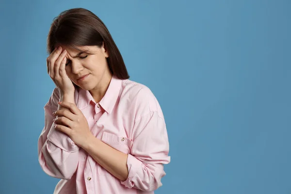 Femeia Tânără Care Suferă Migrenă Fundal Albastru Deschis Spațiu Pentru — Fotografie, imagine de stoc