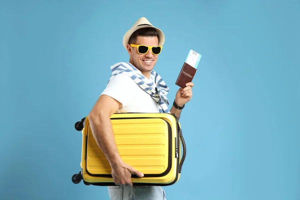 Mężczyzna Turysta Posiadający Paszport Biletem Walizką Turkusowym Tle — Zdjęcie stockowe