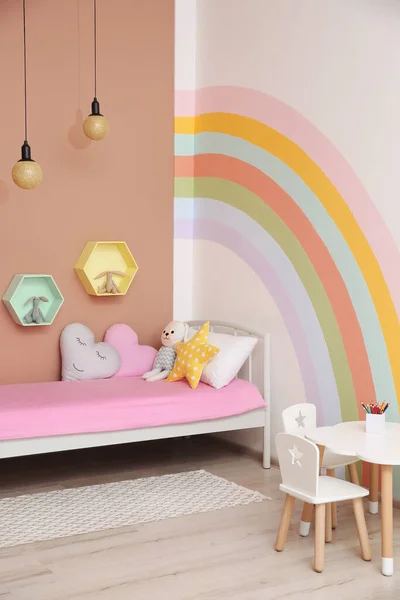 壁に美しい虹が描かれたかわいい子供部屋のインテリア — ストック写真