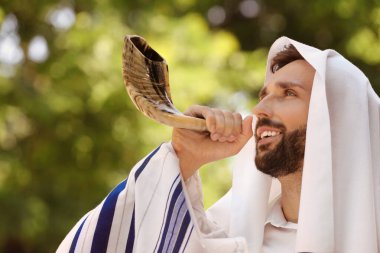 Tallit 'te Yahudi bir adam açık havada hava üflüyor. Rosh Hashanah kutlaması