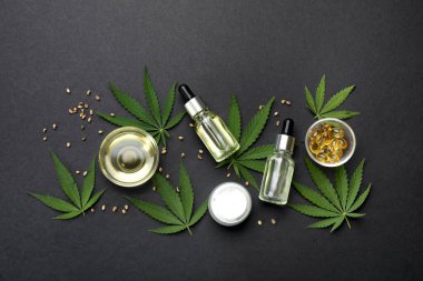 Kenevir yaprakları, CBD yağı ve siyah zemin üzerindeki THC tentürü ile düz konum
