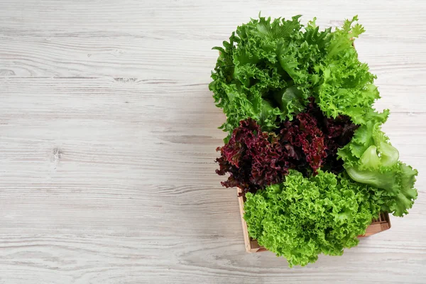 Krat Met Verschillende Soorten Sla Witte Houten Tafel Bovenaanzicht Ruimte — Stockfoto