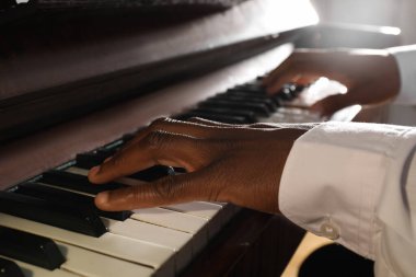 African-American man playing piano, closeup. Talented musician clipart