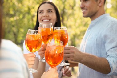 Arkadaşlar bardaklarını tokuşturur Aperol spritz kokteylleri dışarıda, ellere odaklan