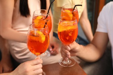 Arkadaşlar bardakları tıkırdatıyor Aperol spritz kokteylleri dışarıda, yakın plan