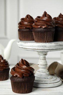 Beyaz ahşap masada kremalı lezzetli çikolatalı kekler.