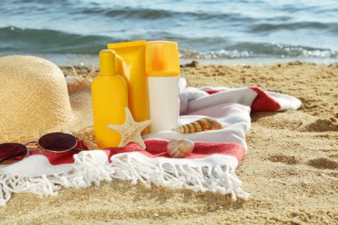 Deniz kenarındaki battaniyede güneş koruma ürünleri ve plaj aksesuarları, metin için yer