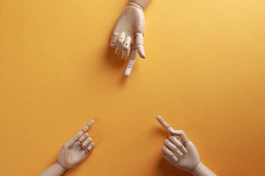 Tahta manken elleri turuncu arka planda, düz yatıyordu.