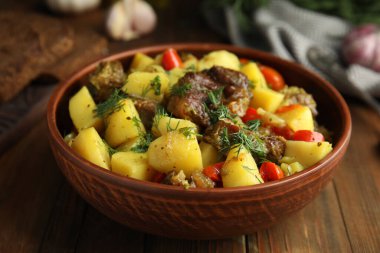 Ahşap masada patatesle pişirilmiş lezzetli bir yemek. Yakın plan.