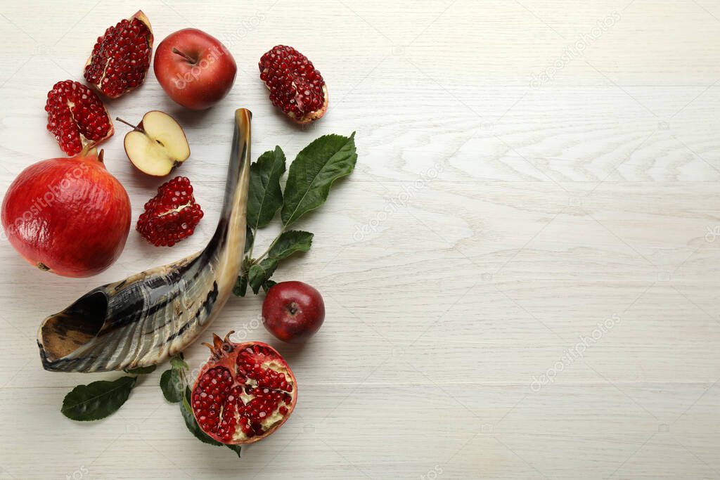 Flat lay composition with Rosh Hashanah holiday attributes on white wooden table. Space for text