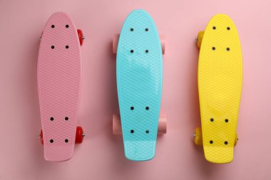 Pembe arka planda renkli kaykaylar, düz yatış