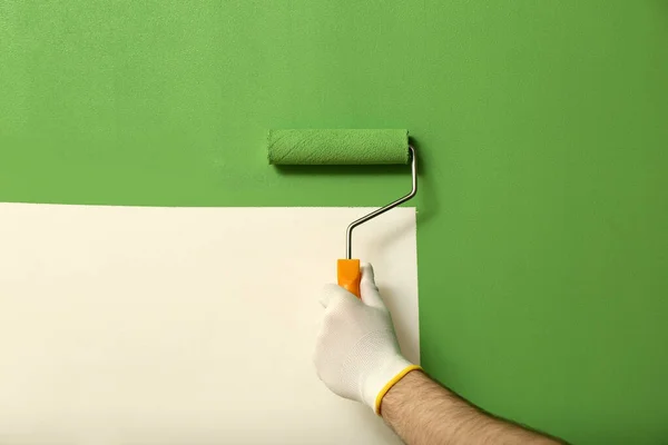 Homem Aplicando Tinta Verde Com Escova Rolo Parede Branca Close — Fotografia de Stock