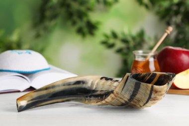 Shofar ve diğer Rosh Hashanah bayramı özellikleri beyaz ahşap masa üzerindedir.
