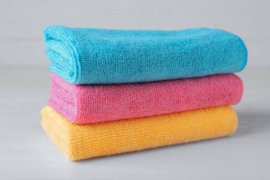 Beyaz masada renkli mikrofiber kumaş yığını, yakın plan.