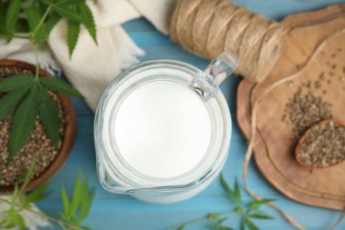 Açık mavi ahşap arka planda bir sürahi kenevir sütü.