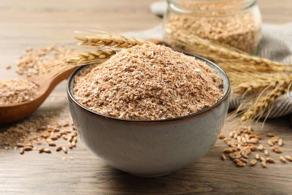 Wheat bran and kernels on wooden table