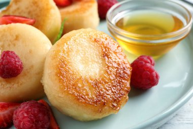 Lezzetli süzme peynirli krep, taze böğürtlen ve bal tabakta, yakın plan.