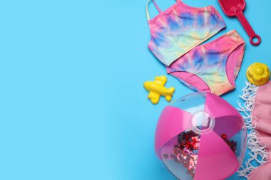 Plaj topu ve kum oyuncakları açık mavi arka planda düz kompozisyon, metin için boşluk