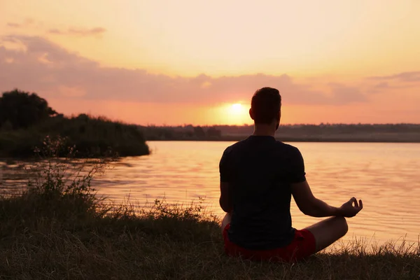 Чоловік Медитує Біля Річки Під Час Заходу Сонця Вид Ззаду — стокове фото