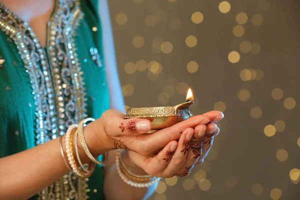 Woman Holding Lit Diya Lamp Brown Background Blurred Lights Closeup — Stock Photo, Image