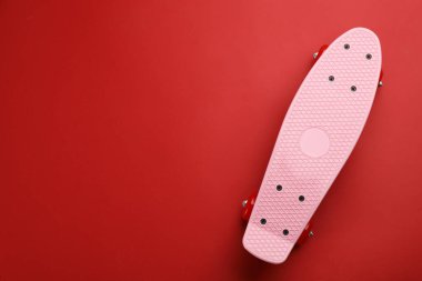 Kırmızı arka planda kaykay, üst manzara. Metin için boşluk