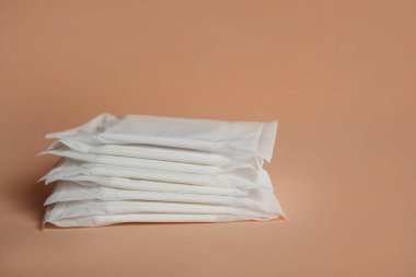 Soluk turuncu arka planda regl pedleri. Jinekolojik bakım