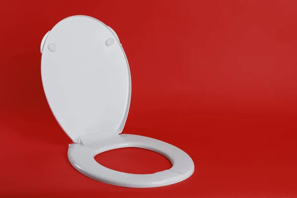 Нове Біле Пластикове Сидіння Туалету Червоному Тлі Простір Тексту — стокове фото
