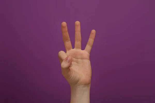 Жінка Показує Три Пальці Фіолетовому Фоні Крупним Планом — стокове фото
